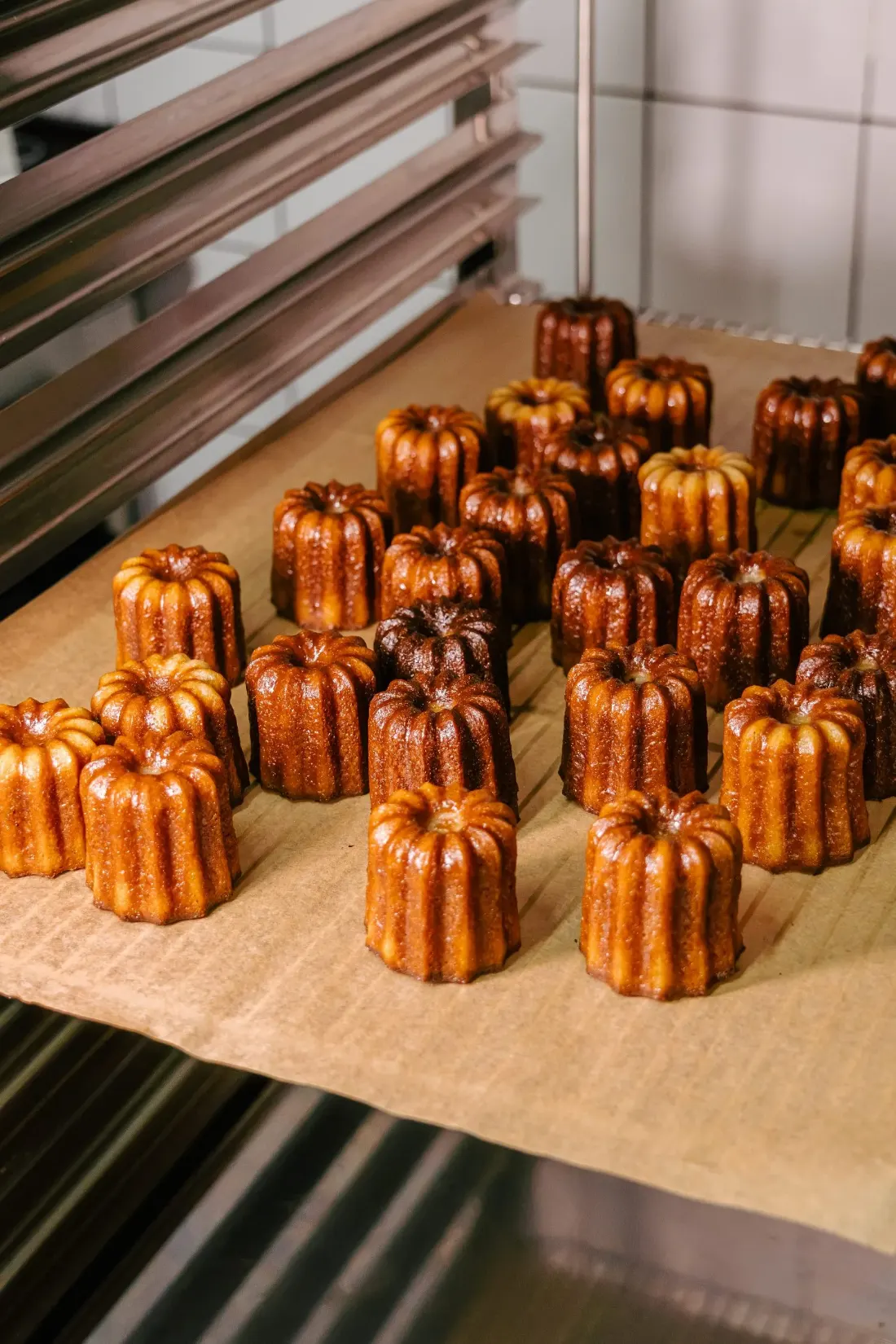 Cannelés dorés tout juste sortis du four sur plaque