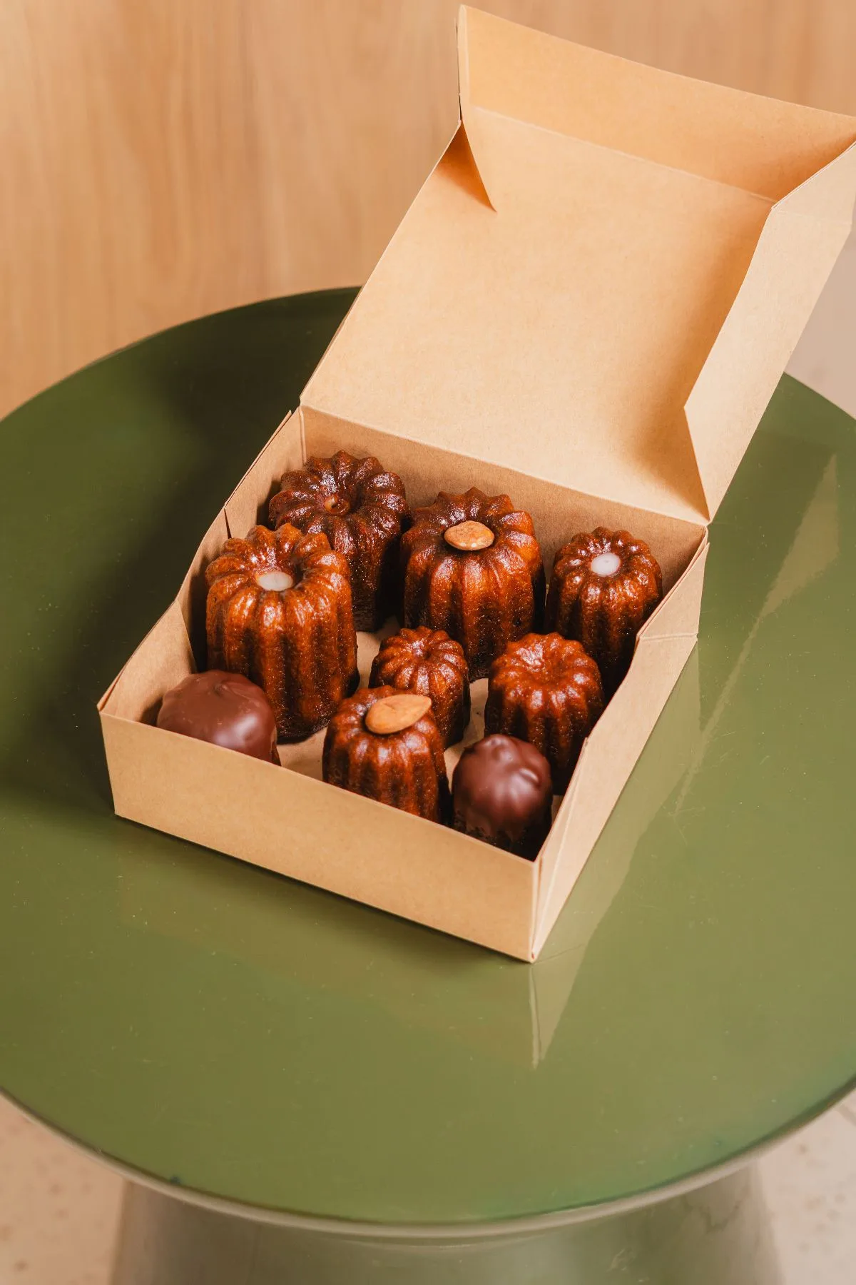 Coffret kraft de cannelés assortis posé sur une table